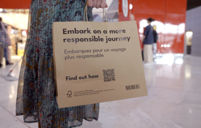 Paper bag with inscription &quot;Embark on a more sustainable journey&quot;
